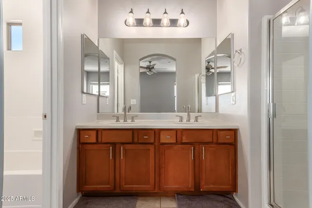 a bathroom with a granite countertop double vanity sink and a mirror
