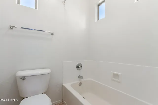 a white toilet sitting next to a bath tub
