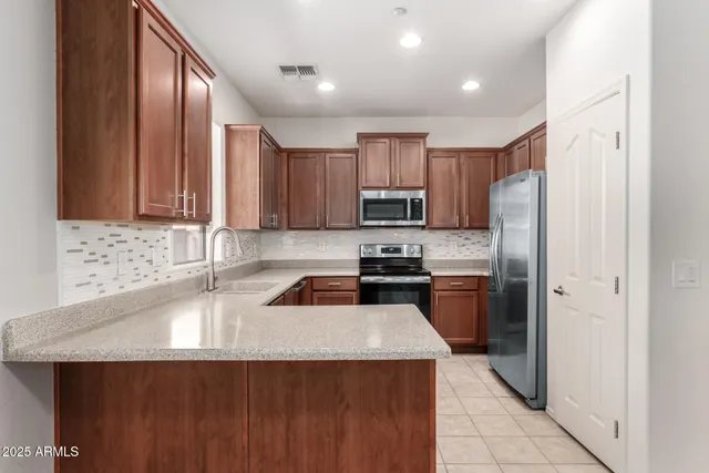 a kitchen with a refrigerator a sink a stove a microwave and wooden cabinets