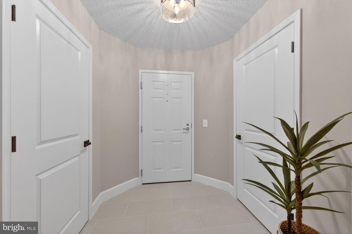 11800 Sunset Hills Road, Unit 314 Reston, VA 20190 - Photo 6 of 50 a view of a hallway with potted plants and a chandelier