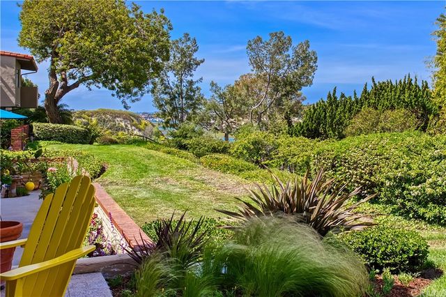 a view of a yard with plants and a bench