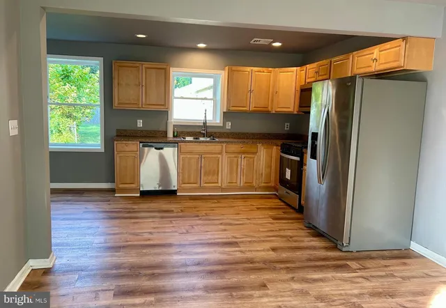 a kitchen with stainless steel appliances granite countertop a refrigerator and a sink