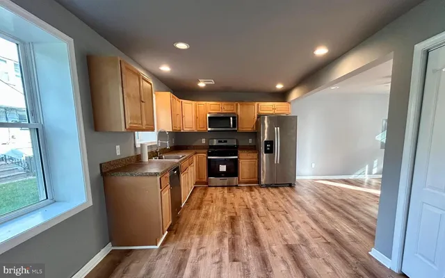 a kitchen with granite countertop a refrigerator and a stove top oven