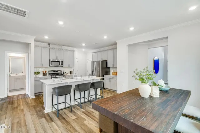 a view of a dining room with furniture wooden floor and a kitchen