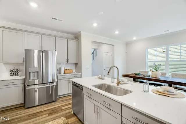 a kitchen with kitchen island a sink appliances and cabinets