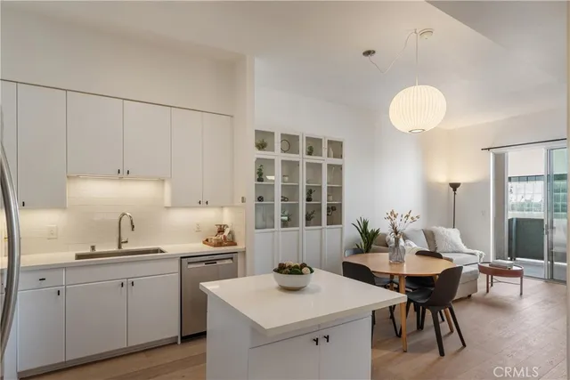 a kitchen with a table chairs and white cabinets