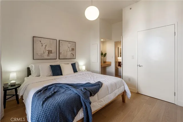 a bedroom with a bed and painting on the wall