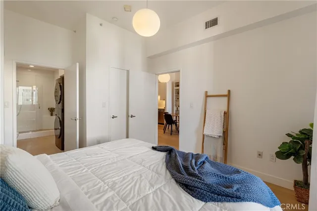 a bedroom with a bed and a mirror on the dresser