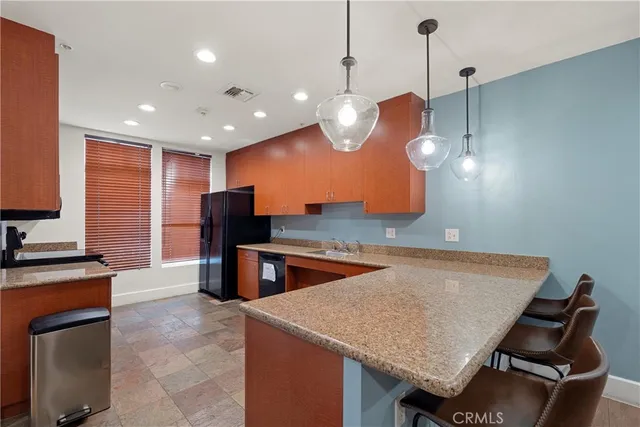 a kitchen with stainless steel appliances granite countertop a sink a stove and a refrigerator