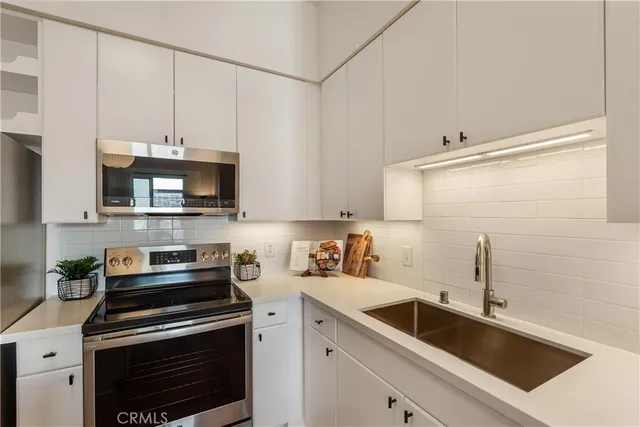 a kitchen with stainless steel appliances a stove a sink and a microwave