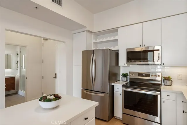 a kitchen with stainless steel appliances a refrigerator a stove and a sink