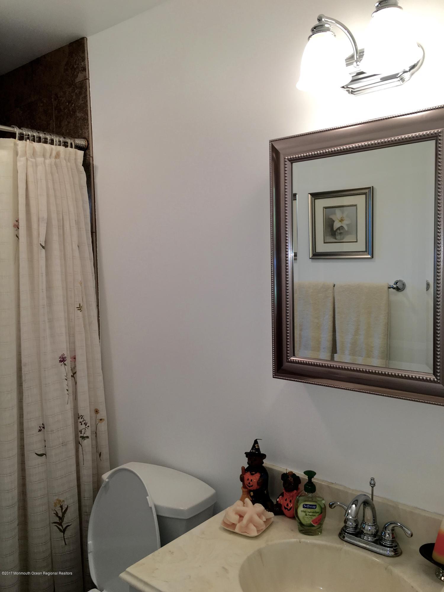 10 Fenimore Road Freehold, NJ 07728 - Photo 19 of 36 a bathroom with a sink and mirror with toilet