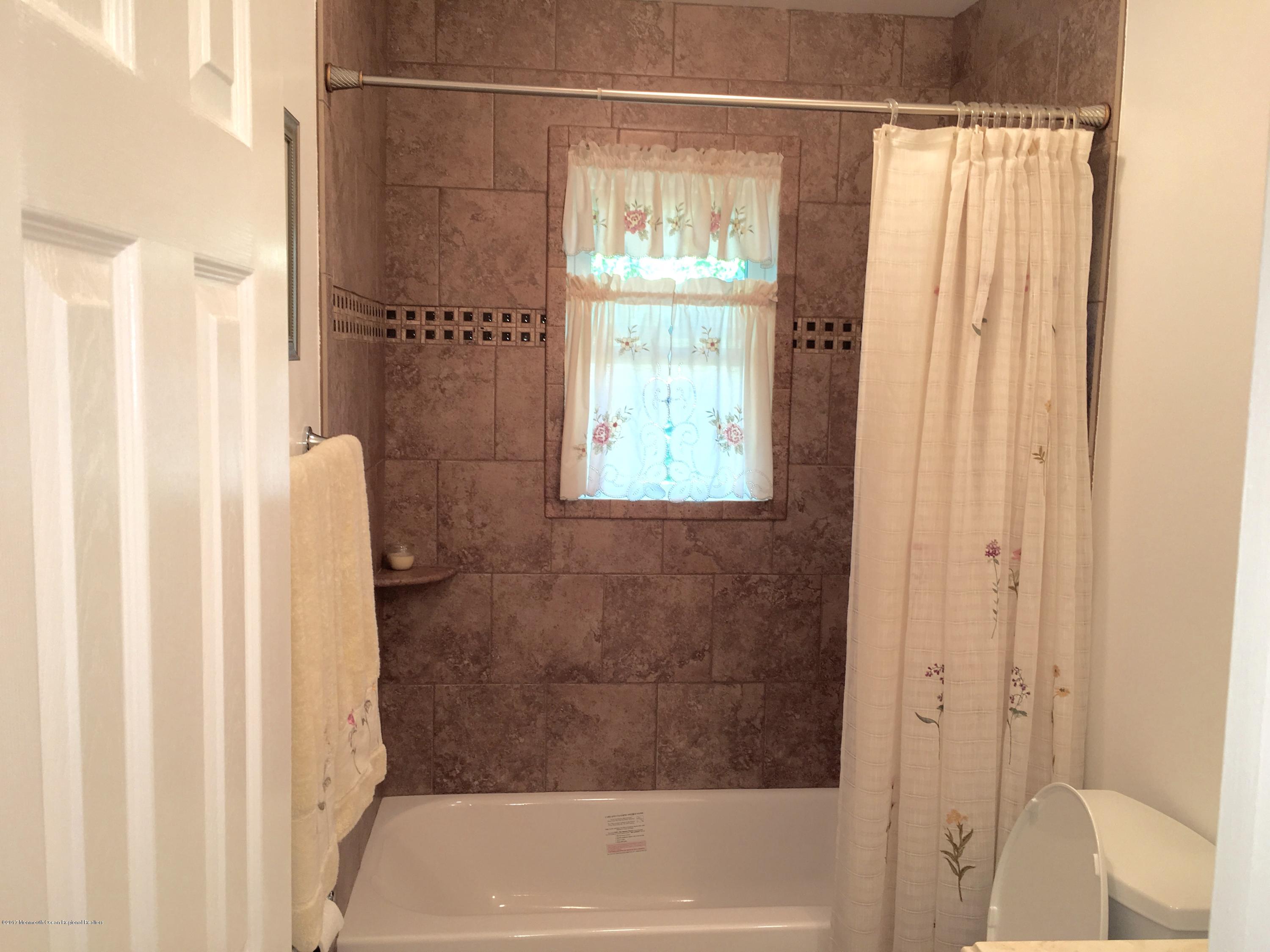 10 Fenimore Road Freehold, NJ 07728 - Photo 20 of 36 a bathroom with a shower and a bath tub