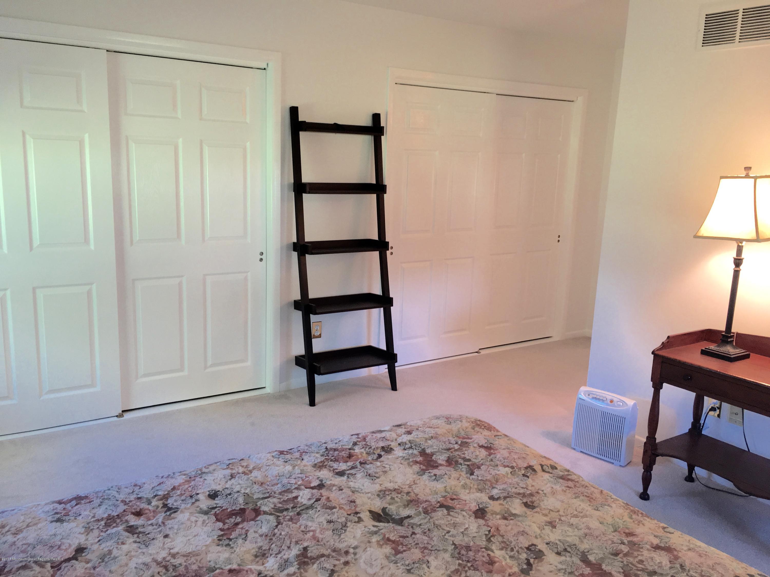 10 Fenimore Road Freehold, NJ 07728 - Photo 22 of 36 a bedroom with a bed and a lamp on table