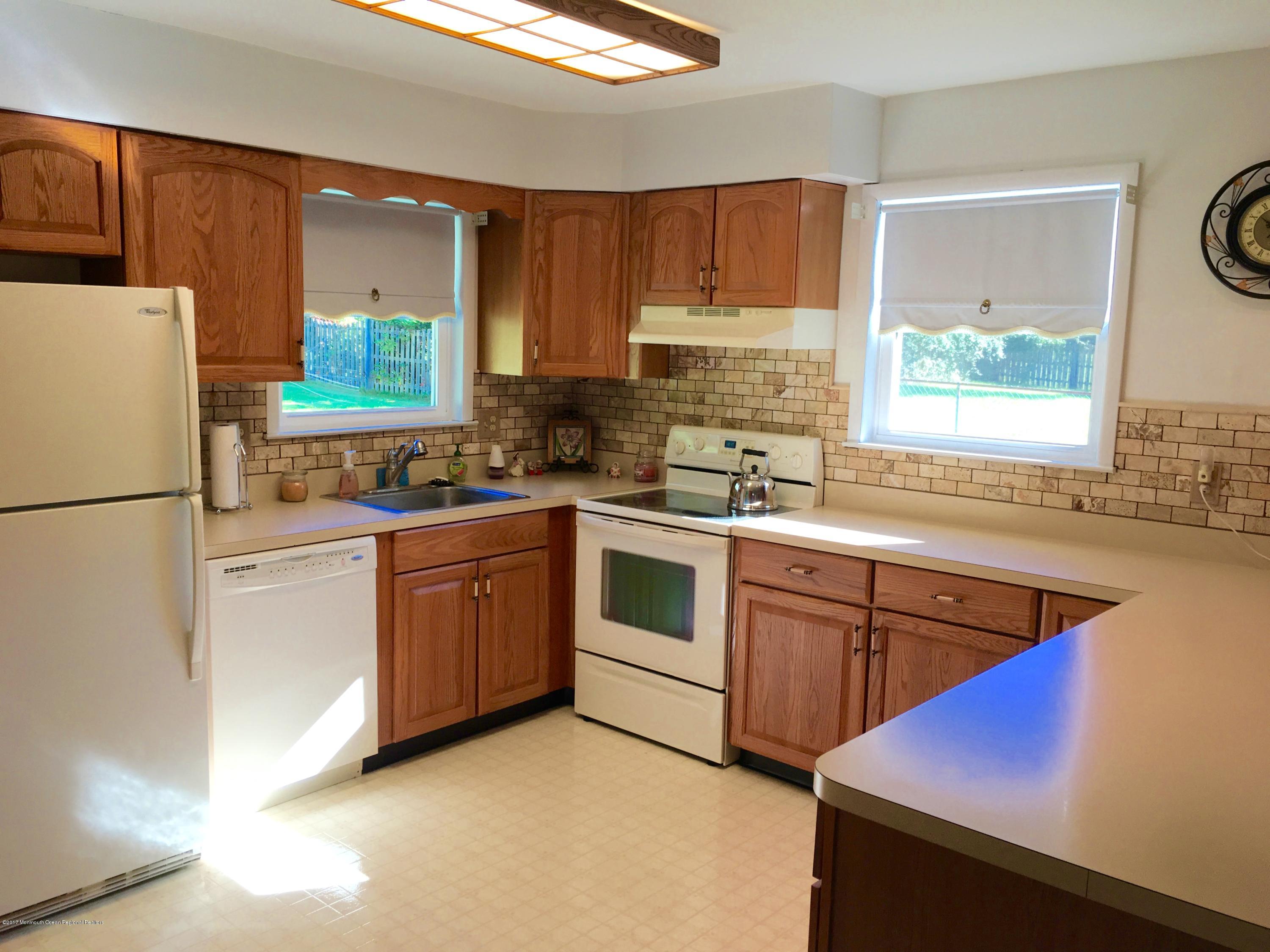 10 Fenimore Road Freehold, NJ 07728 - Photo 3 of 36 a kitchen with a sink stove and refrigerator