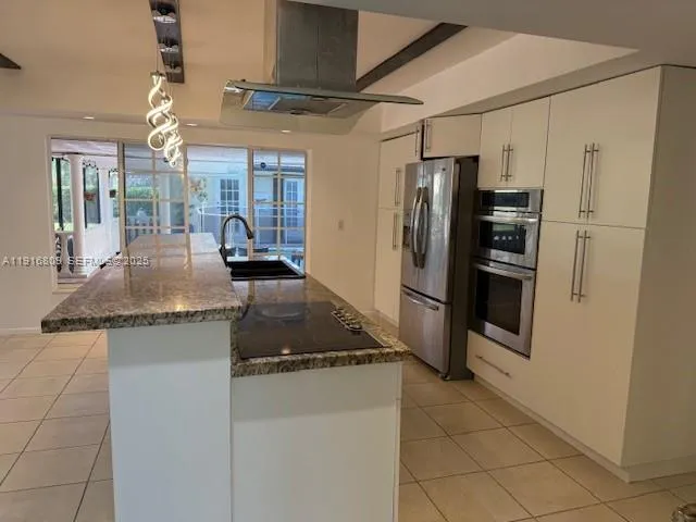a kitchen with granite countertop a refrigerator and a sink