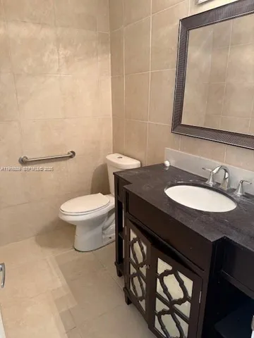 a bathroom with a granite countertop sink toilet and a mirror