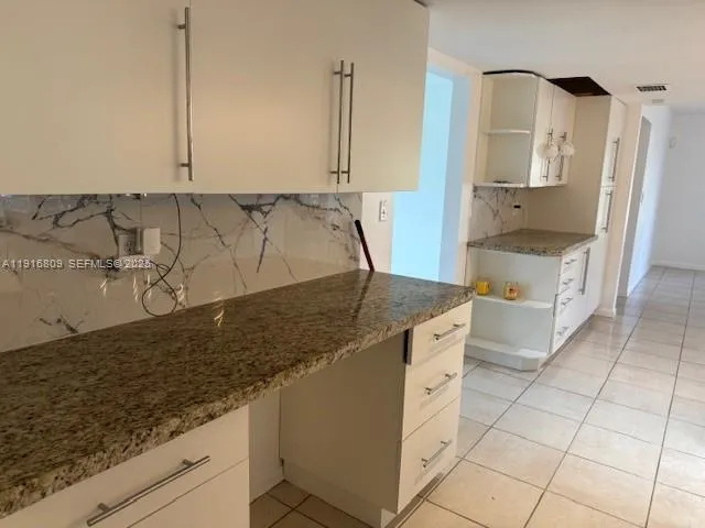 a spacious bathroom with a granite countertop sink and a mirror