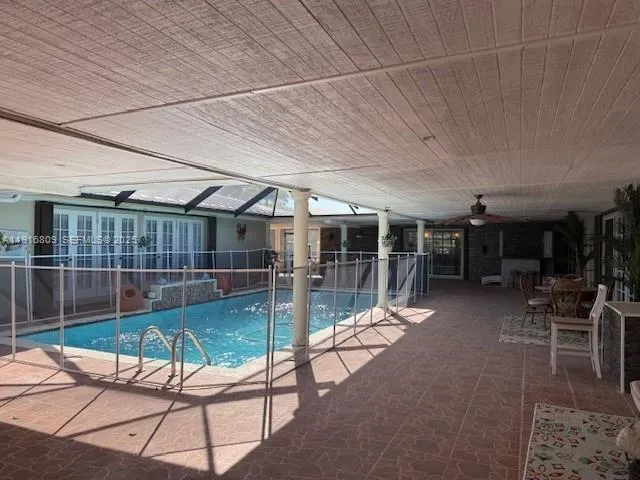 a view of a patio with table and chairs with wooden floor and fence