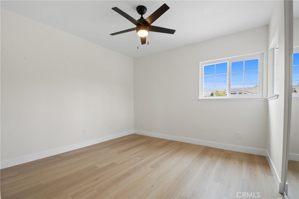 921 Boon Place, Unit A Corona, CA 92881 - Photo 15 of 21 an empty room with wooden floor and windows