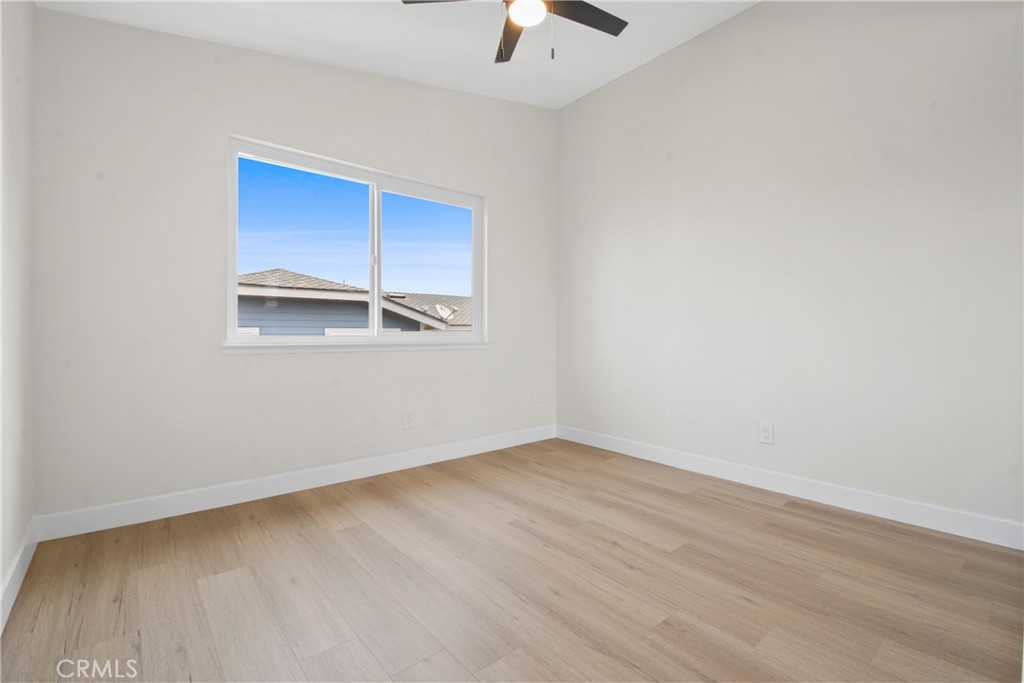 921 Boon Place, Unit A Corona, CA 92881 - Photo 17 of 21 an empty room with a ceiling fan and windows