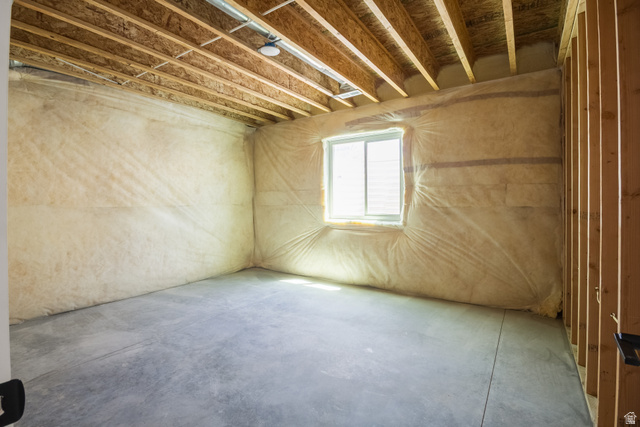 3322 250 S Street Vernal, UT 84078 - Photo 29 of 37 Unfinished basement room featuring a concrete floor, exposed wood ceiling joists, and a vinyl window with blinds