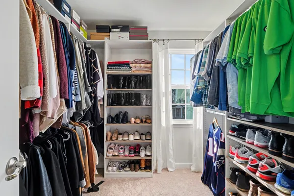 a view of walk in closet with clothes and shoes