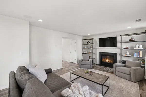 a living room with furniture a fireplace and a flat screen tv