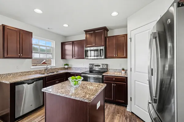 a kitchen with stainless steel appliances granite countertop a sink stove and refrigerator