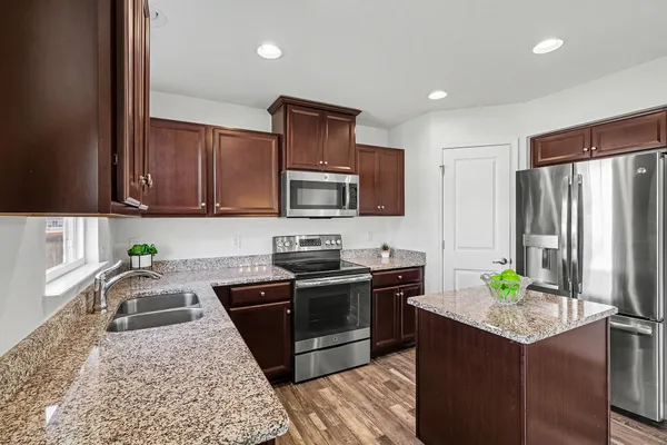 a kitchen with stainless steel appliances granite countertop a sink stove and refrigerator