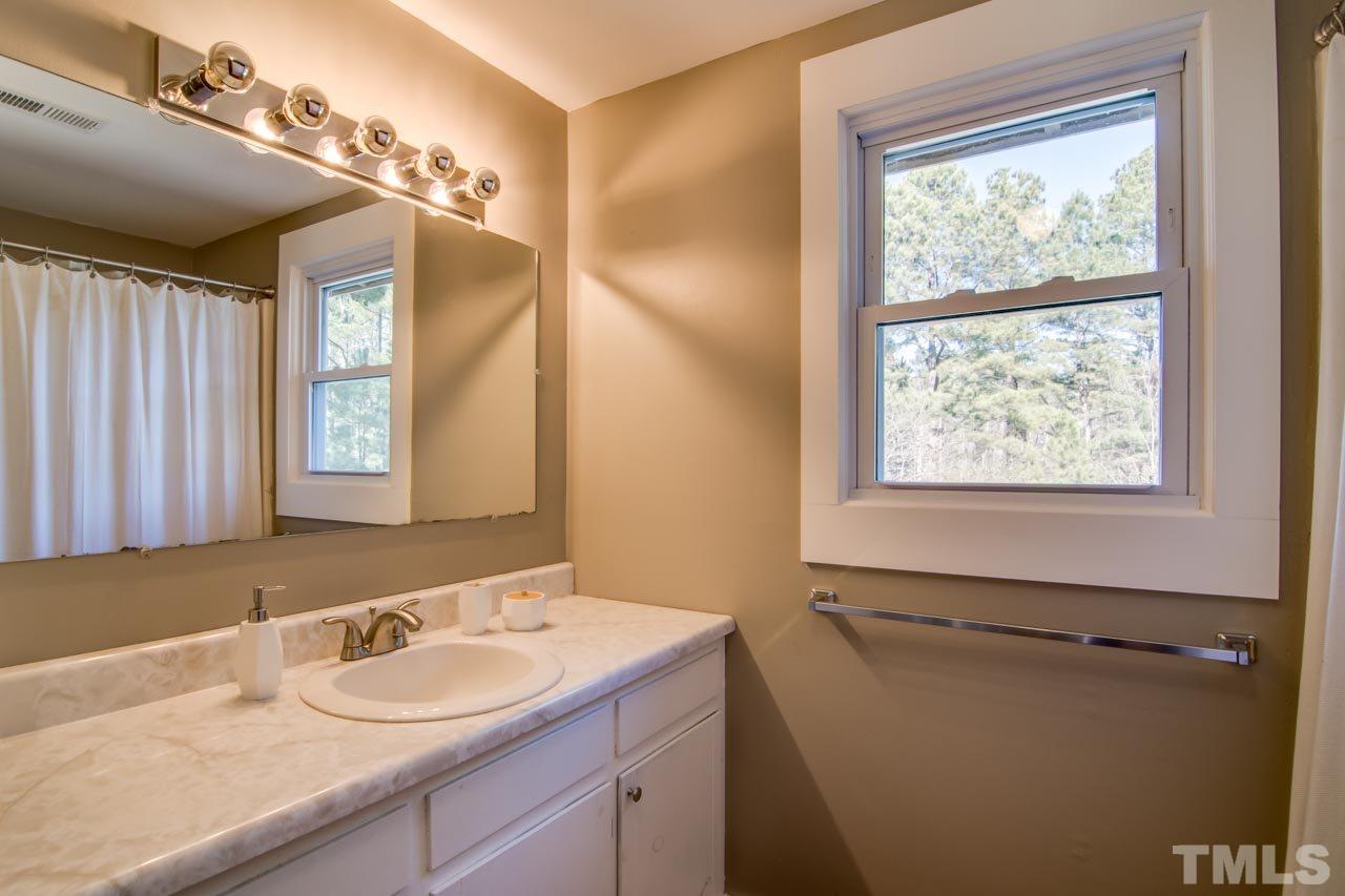 2704 Mt Vernon Church Road Raleigh, NC 27613 - Photo 14 of 23 a bathroom with a granite countertop sink mirror and a window