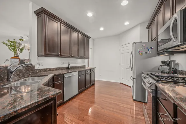 a kitchen with stainless steel appliances granite countertop a sink stove and refrigerator