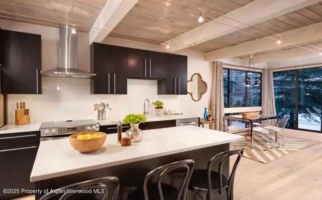 a kitchen with stainless steel appliances a sink a stove and chairs