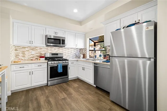 a kitchen with stainless steel appliances a refrigerator sink and microwave