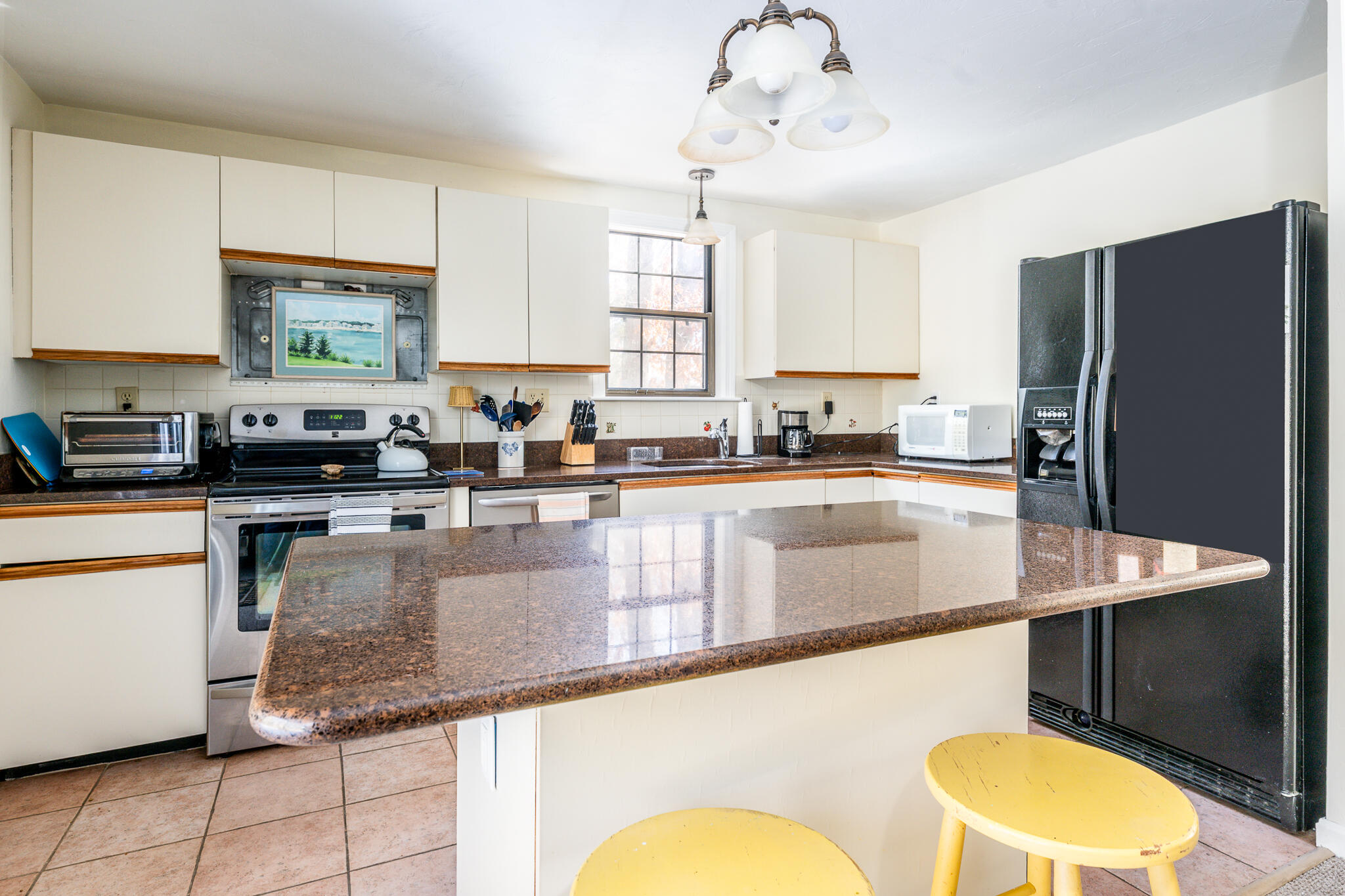 195 Falmouth Road, Unit 9F Mashpee, MA 02649 - Photo 11 of 35 a kitchen with stainless steel appliances granite countertop a sink a stove a refrigerator a center island and cabinets