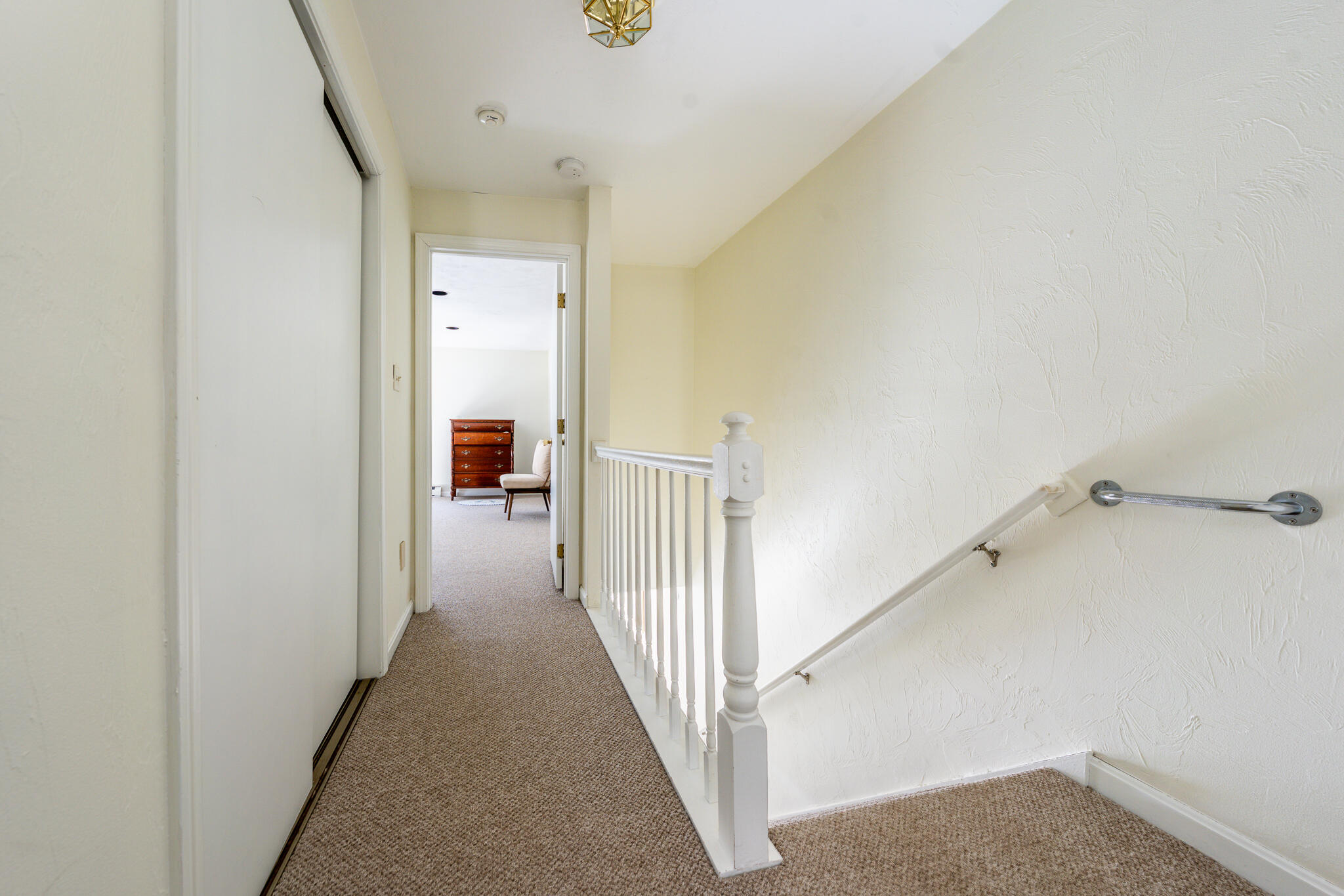 195 Falmouth Road, Unit 9F Mashpee, MA 02649 - Photo 22 of 35 a view of a hallway with white walls and stairs