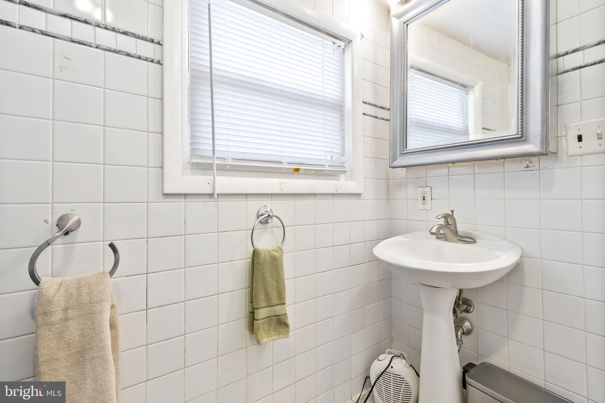111 Thompson Street Burlington, NJ 08016 - Photo 18 of 25 a bathroom with a sink a mirror and a window
