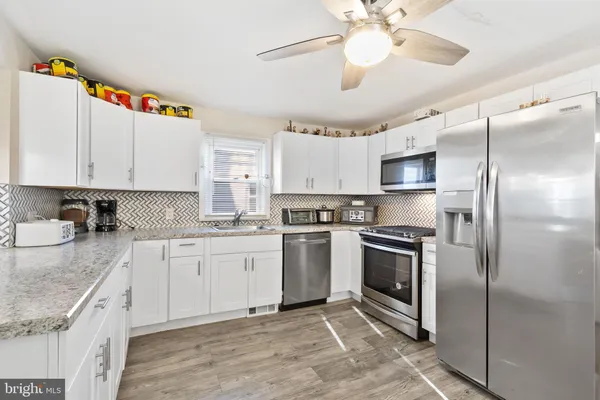 a kitchen with cabinets stainless steel appliances and a chandelier