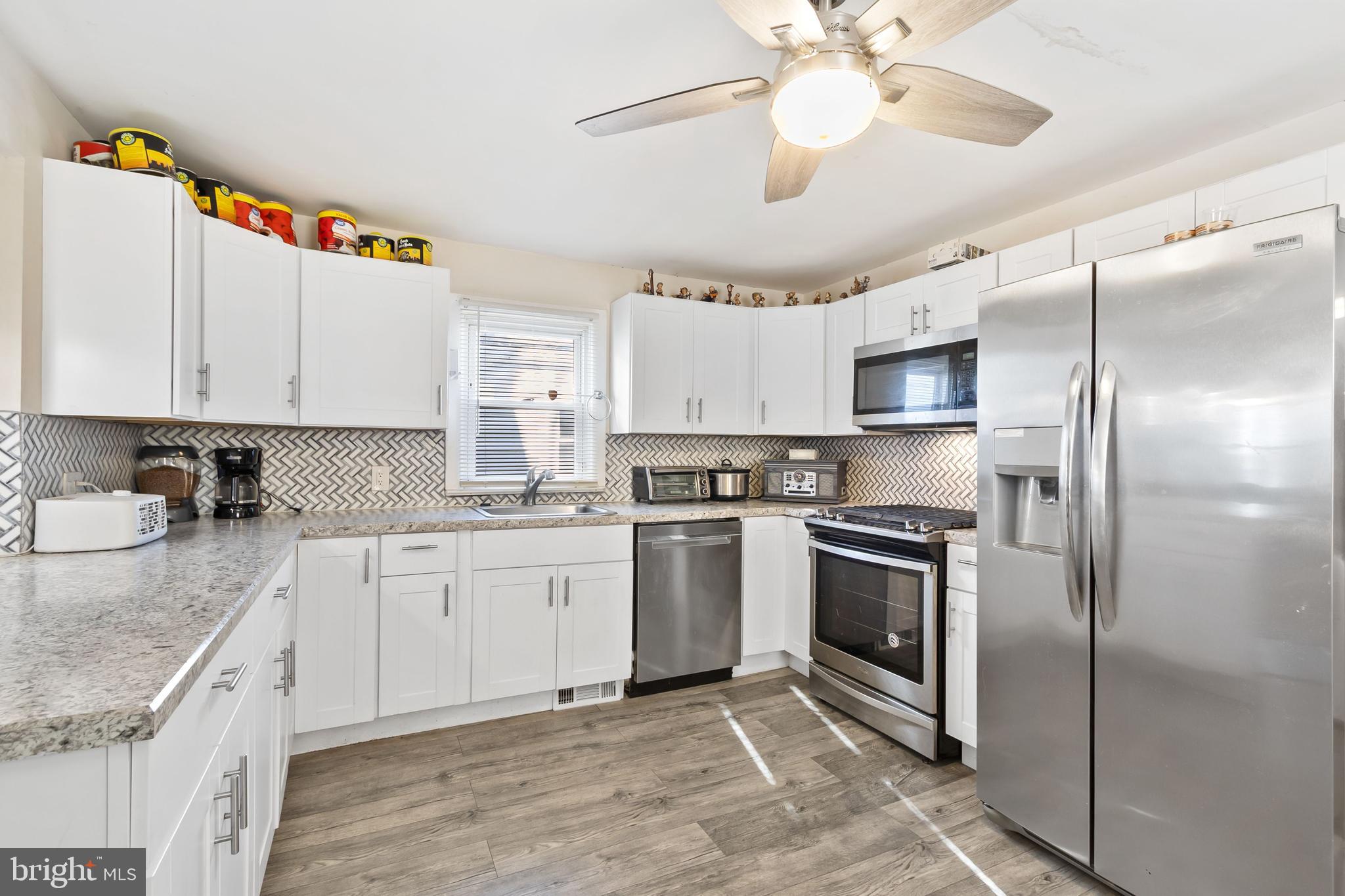 111 Thompson Street Burlington, NJ 08016 - Photo 2 of 25 a kitchen with cabinets stainless steel appliances and a chandelier