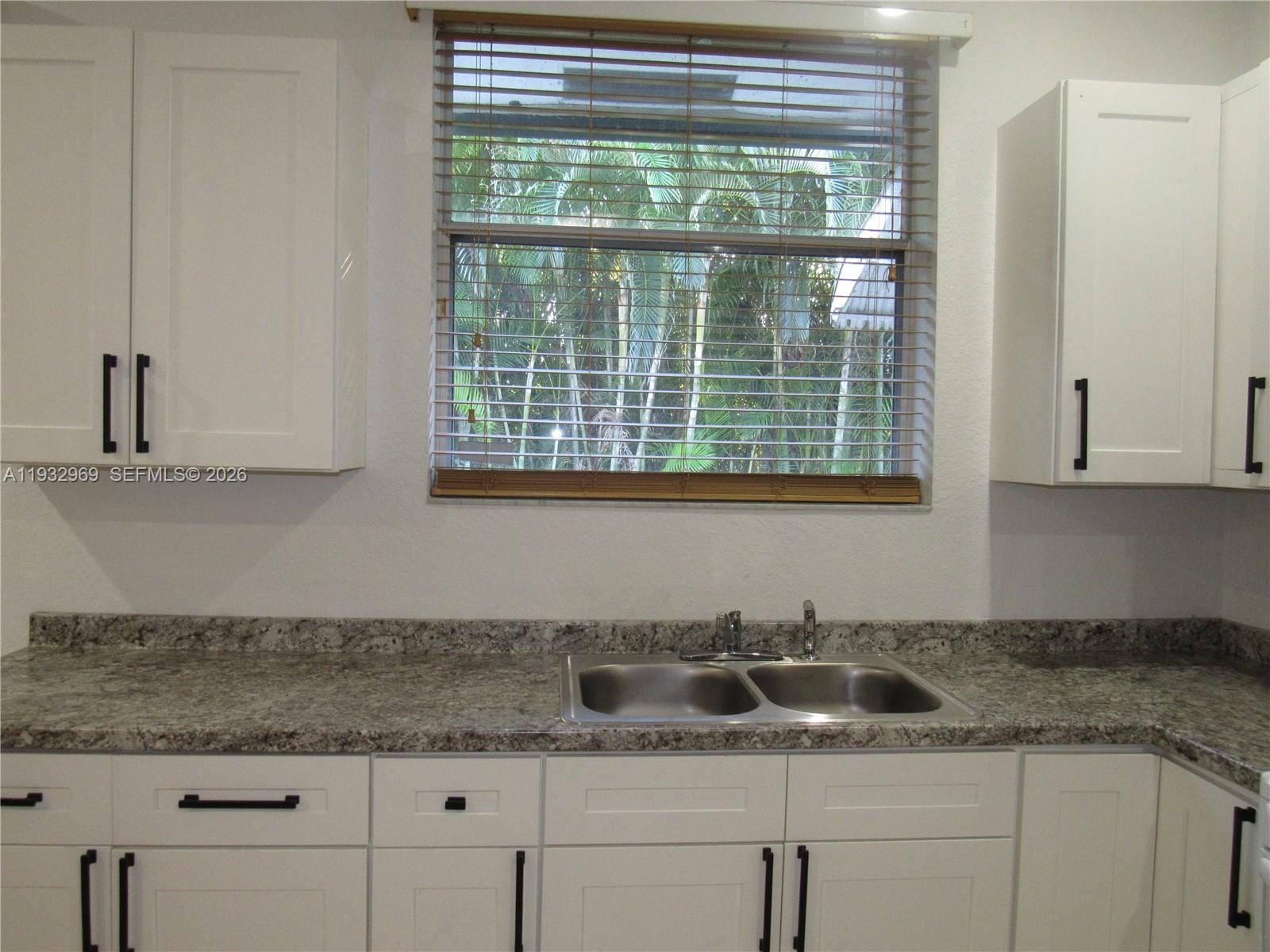15900 Southwest 54th Place, Unit 1 Southwest Ranches, FL 33331 - Photo 6 of 15 a kitchen with granite countertop a sink and a window