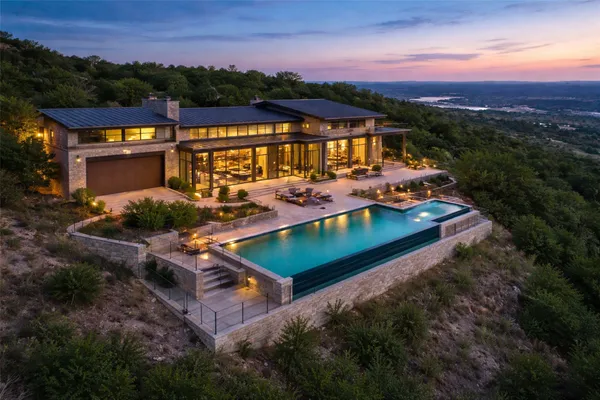 a view of a house with pool and chairs