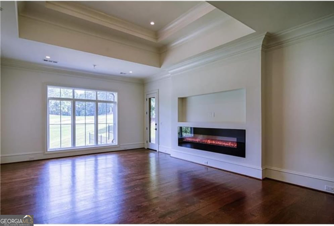 3084 Watson's Bend Milton, GA 30004 - Photo 30 of 95 a view of an empty room with window wooden floor and fire place