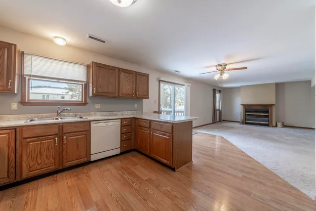 a large kitchen with wooden floors and stainless steel appliances