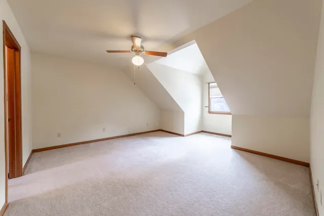 an empty room with windows and fan chandelier