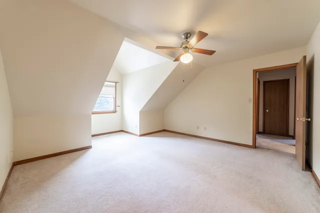 an empty room with a ceiling fan and a window
