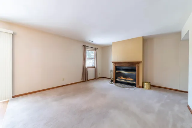 a view of an empty room with a fireplace and a window