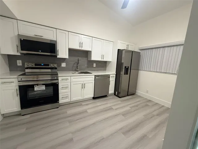 a kitchen with stainless steel appliances a stove microwave and sink