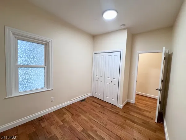 an empty room with wooden floor and a window