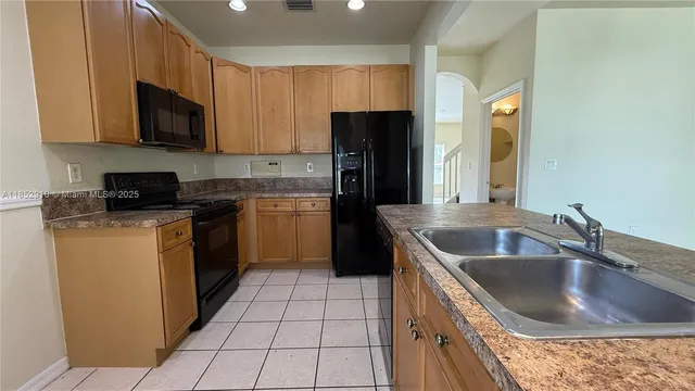 a kitchen with a sink stove top oven and refrigerator