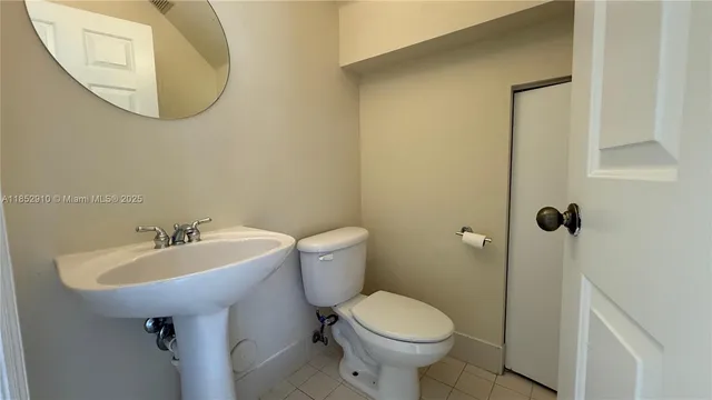 a bathroom with a sink toilet and a mirror